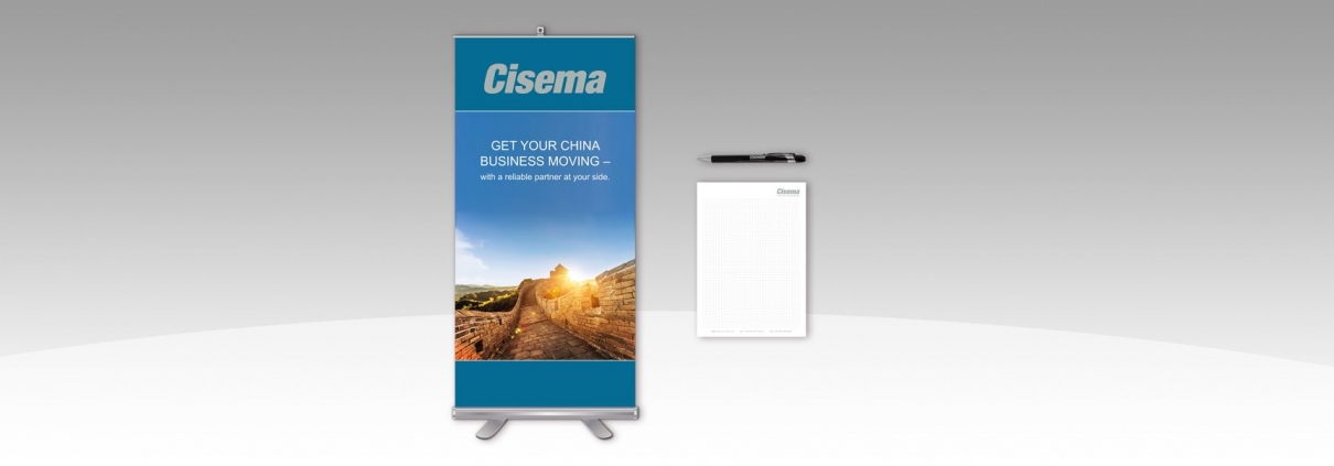 Hier ist ein Rollup sowie ein Notizblock und ein Kugelschreiber von Cisema abgebildet.